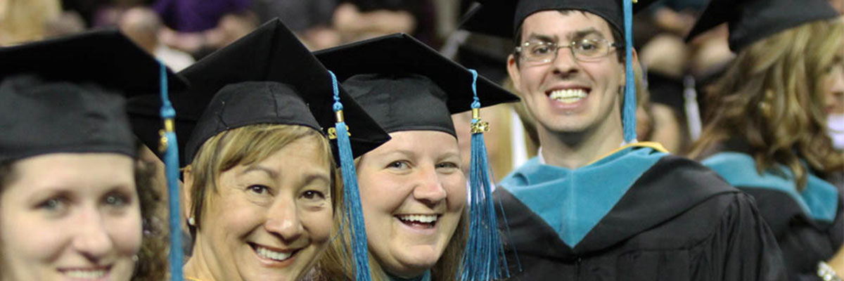 SPA graduates smile in commencement attire.